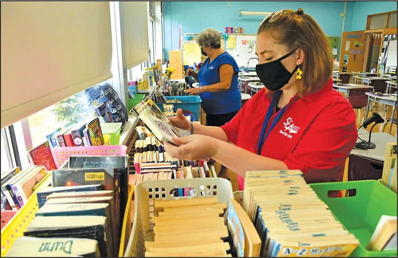 Special education teacher Olivia Baker, right, spent a recent afternoon organizing books with Springfield Education Association Vice President Brenda Dunn at the Daniel B. Brunton School.