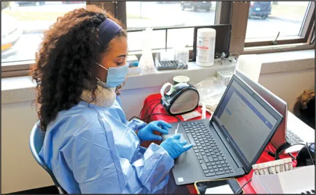 Watertown school nurse Bianca Jones, above, kept notes during pooled surveillance testing for COVID-19