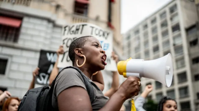 An activist at a rally holding a megaphone.