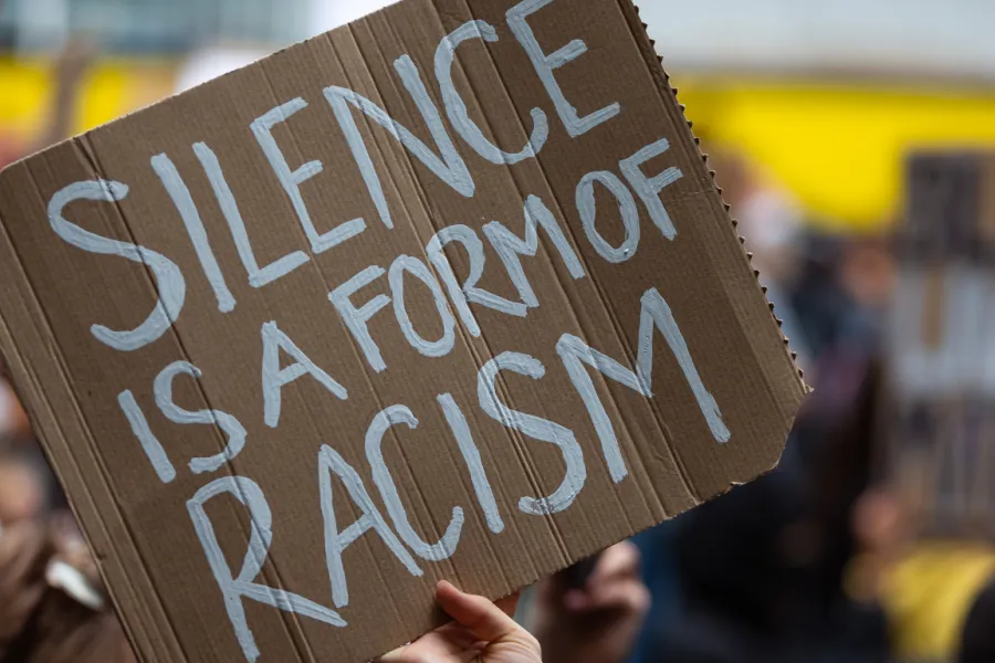 Sign reads, “Silence is a form of racism.”